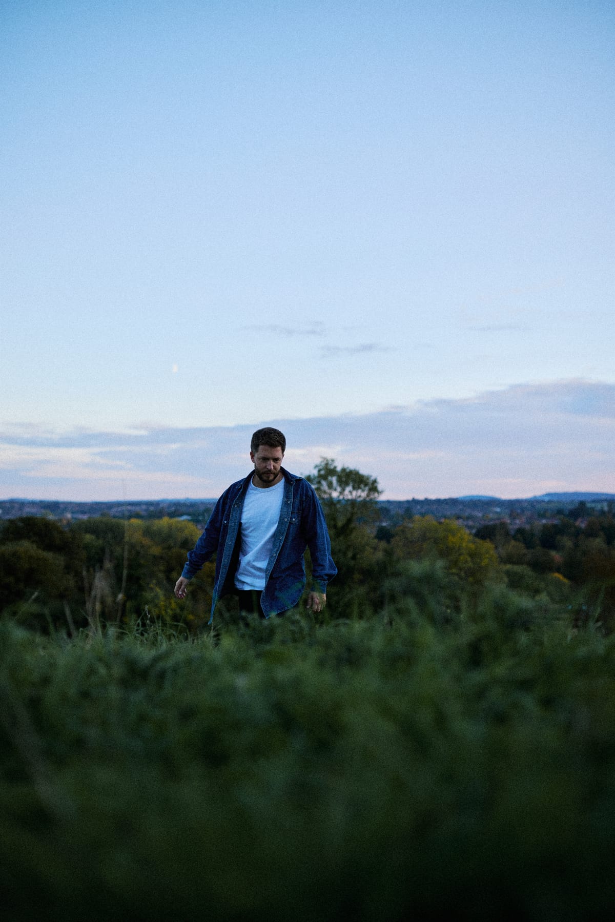 Josh Smith standing in long grass at dusk